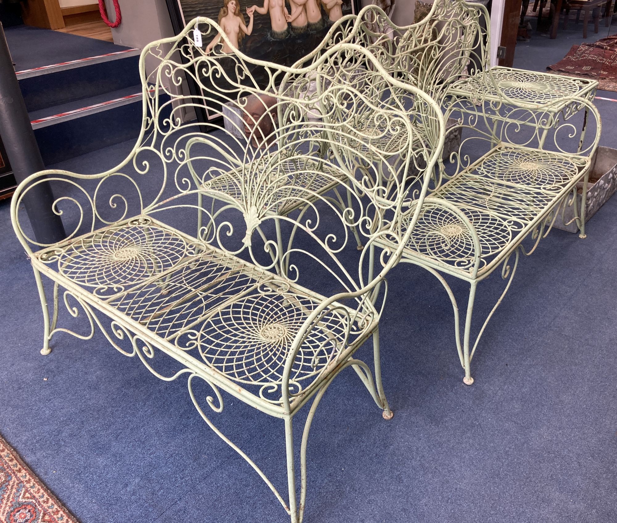 A French painted wrought iron garden suite comprising a pair of benches, length 122cm, depth 62cm, height 108cm, a pair of chairs and a table
